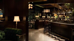 A modern bar area with a checkered floor, bar stools, and pendant lighting. - Daniella's Suites (Peabody)