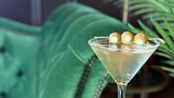 Una copa de martini con tres adornos esféricos sobre una superficie reflectante.