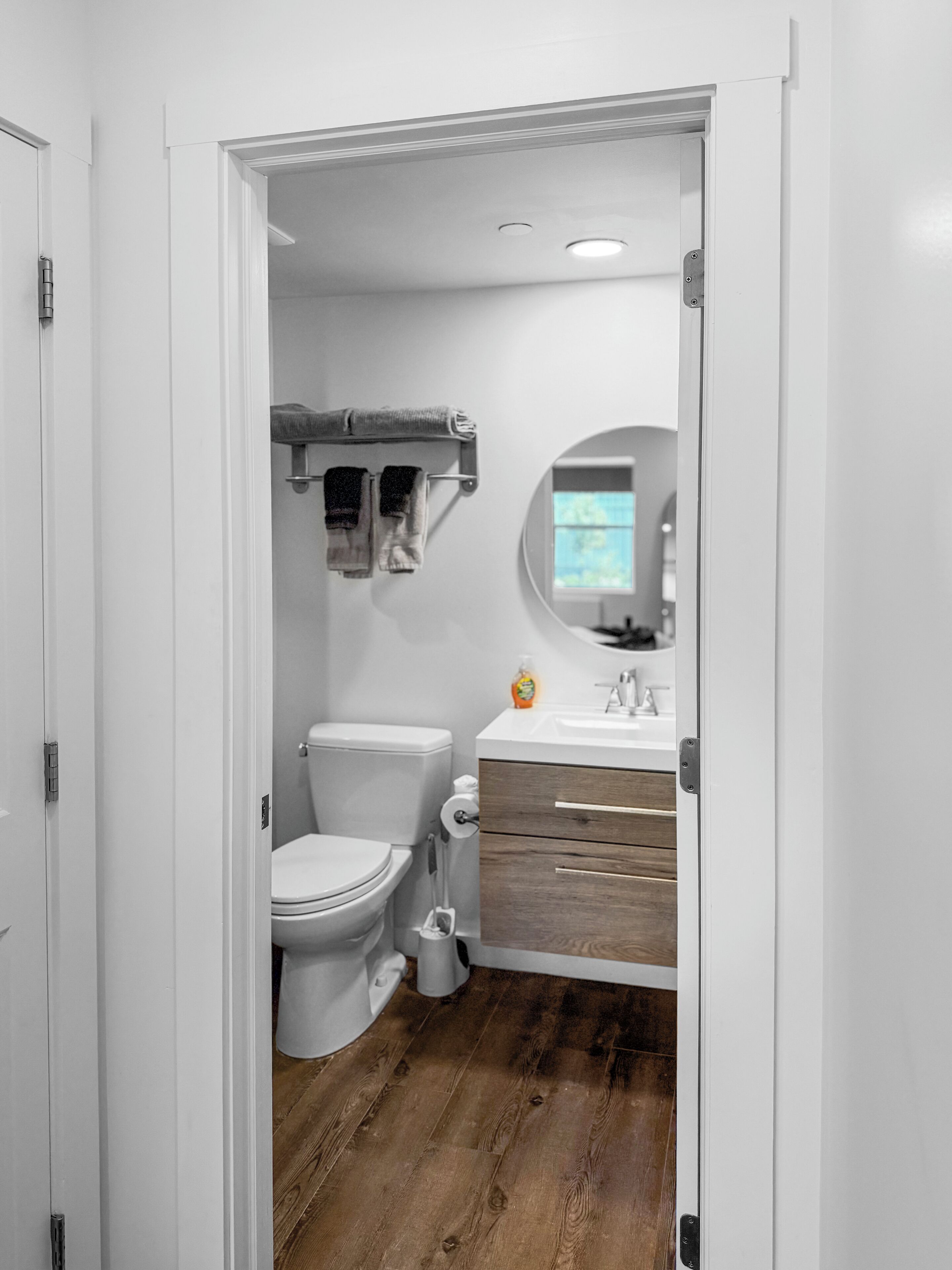 A bathroom with a toilet, a sink, and a mirror.
