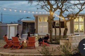 Un patio con mobiliario exterior e iluminación con guirnaldas.