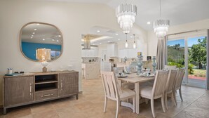 A spacious dining area with a large round mirror, a buffet-style cabinet, and a chandelier. - Villa Francisca East-Spacious 3Bedroom Retreat with A/C – Your Perfect Getaway (St Thomas)