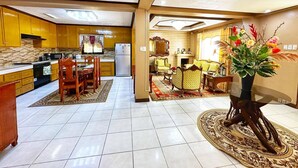 Un espacio habitable amplio con una mesa de comedor, sofás y un jarrón decorativo.