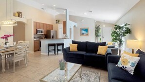A modern apartment with a kitchen, dining area, and living room. - Beautiful Disney Home! Heated Pool/Spa • Arcade • Gated Community • 4BR / 3BA (Kissimmee)