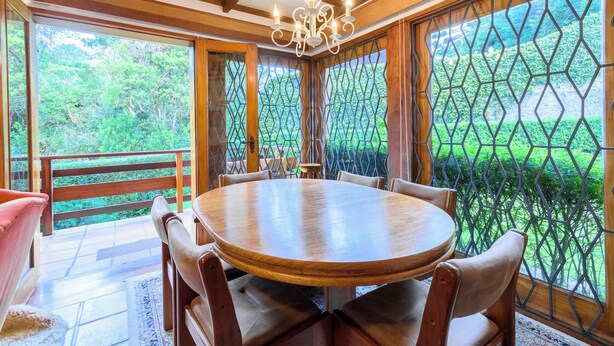 A dining area with a round wooden table, six chairs, and a chandelier.