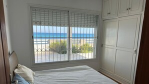 Una camera da letto con un letto, una finestra vista mare e un armadio.