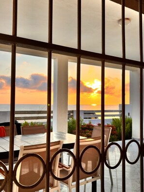 A terrace with a sunset view, featuring a table and chairs, and a railing with circular designs. - RDC Villa OZ Sounine Rafraf (Sounine)