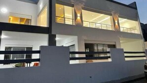 Un edificio moderno a due piani con ampie finestre e un balcone.