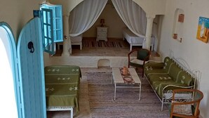 Ein Zimmer mit einem Bett, einem kleinen Tisch, einer Couch, einem Sessel und einem Kleiderschrank.