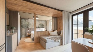 Une chambre moderne avec un lit, un bureau et une vue sur les montagnes.