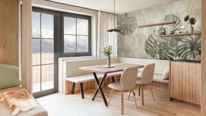 Ein moderner Essbereich mit Holztisch, zwei Stühlen, einer Bank und Bergblick durch große Fenster.