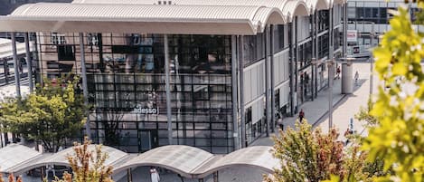 Un edificio moderno con fachada de vidrio y un área de acceso cubierta.