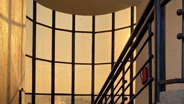 A staircase with a metal railing leading to a high ceiling. - Casa Verde – Your Serene Escape in the Heart of Karen (Nairobi)