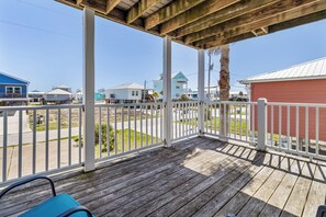 A wooden deck with a white railing, overlooking a street with houses and a clear sky. - Beach Memories by Southern Vacation Rentals (Gulf Shores)