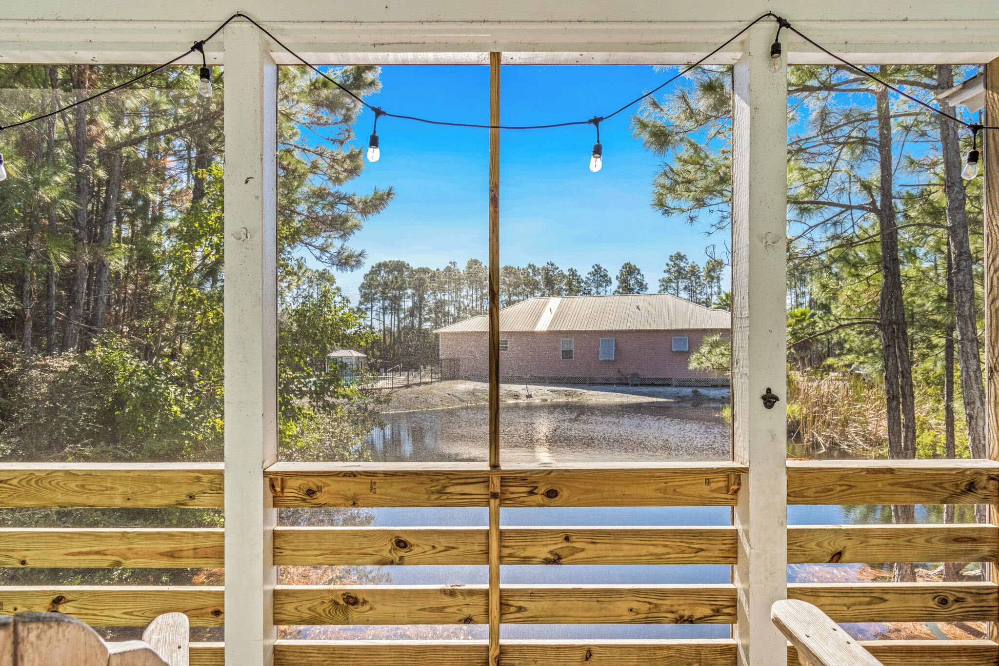 Une terrasse en bois offrant une vue sur une maison et les arbres environnants.
