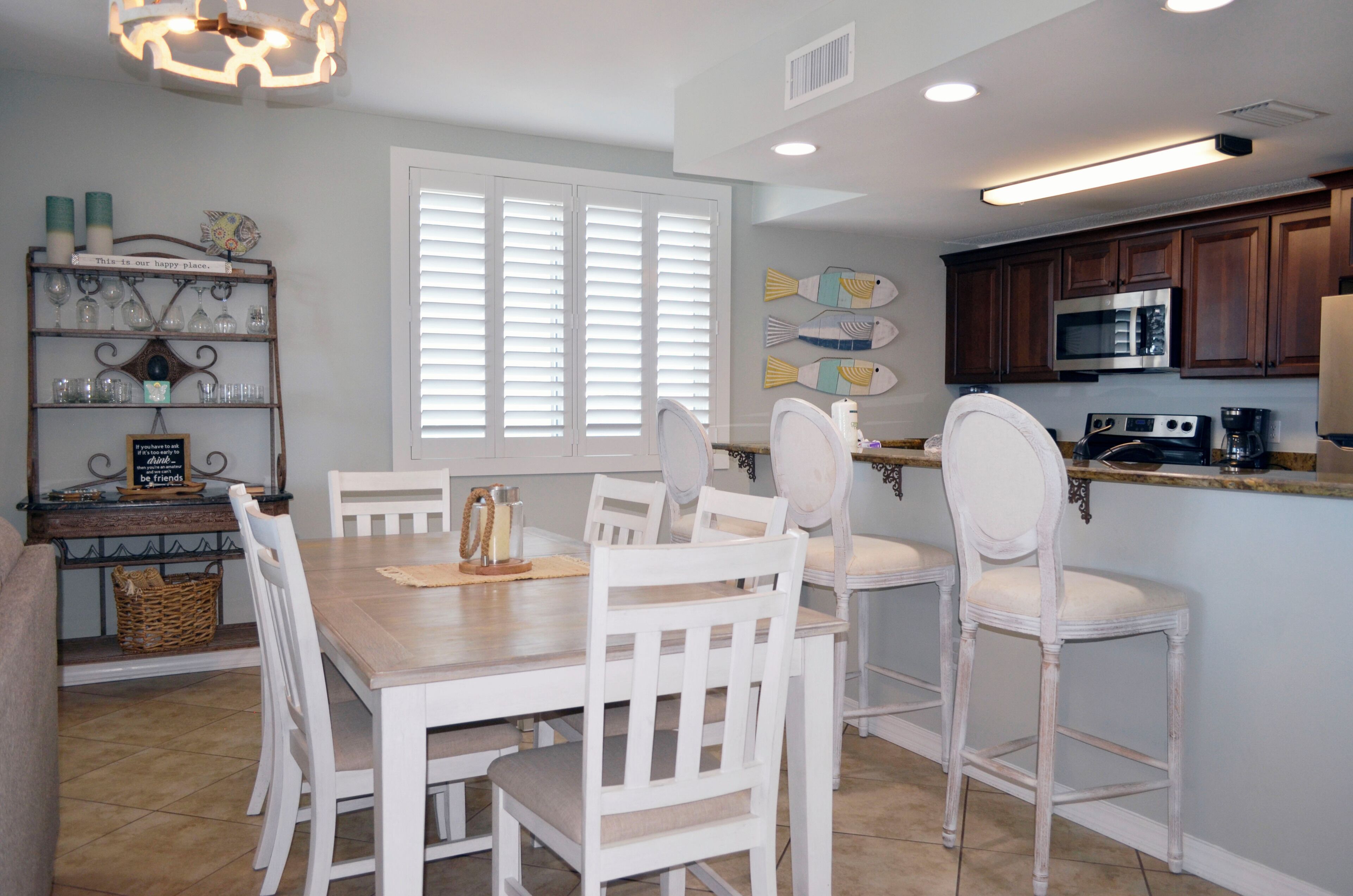 A kitchen with white cabinetry, a microwave, and a coffee maker.