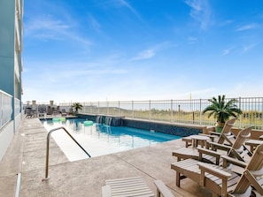 A rooftop pool with lounge chairs and a small waterfall feature. - Emerald Key by Southern Vacation Rentals (Orange Beach)