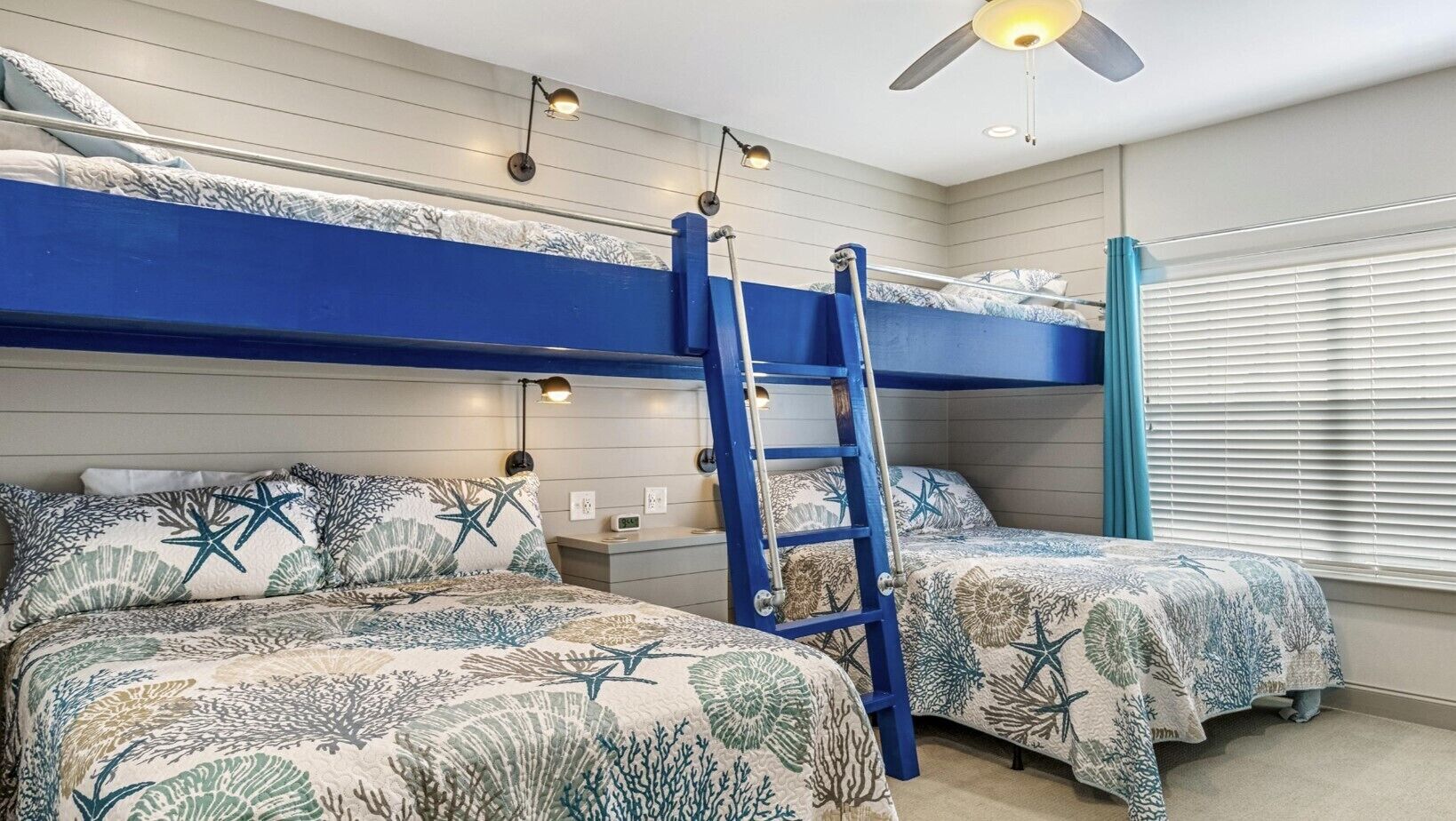 A bedroom with bunk beds, a ladder, and a ceiling fan.