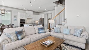 A modern living room with a sectional sofa, wooden coffee table, and a ceiling fan. - Endless Summer by Southern Vacation Rentals (Orange Beach)