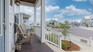 A porch with Adirondack chairs, a lantern, and a small tree. - Endless Summer by Southern Vacation Rentals (Orange Beach)