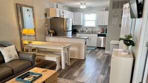 A compact living space with a kitchenette, a dining area, and a seating area with a sofa and a coffee table. - Sunrise Village #216 by Southern Vacation Rentals (Gulf Shores)