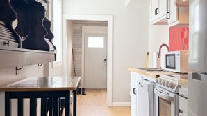 Una cocina moderna con encimera de madera, estufa integrada y armarios blancos.