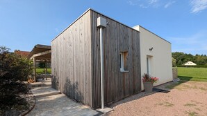 Un edificio moderno con facciata in legno, una piccola finestra e un ingresso.