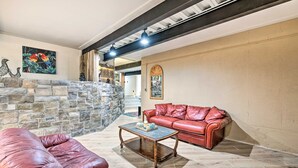 A living room with a stone fireplace, leather sofa, and a coffee table.