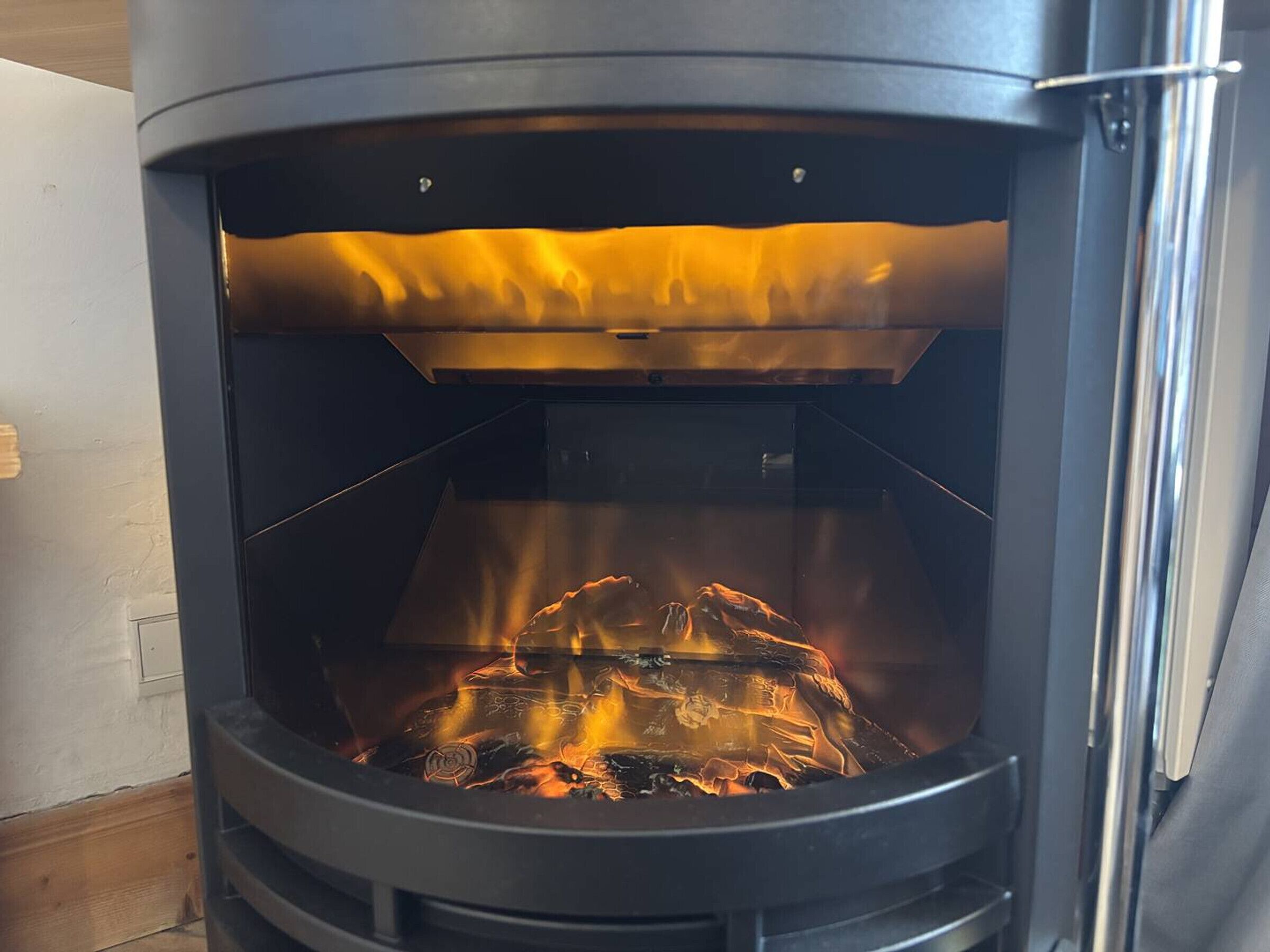 Ein Kaminofen mit sichtbarem Feuer darin.