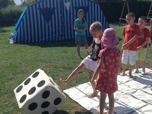 Des enfants jouent avec un grand dé à l’extérieur.