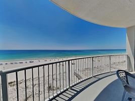 A balcony with a view of a beach and ocean.