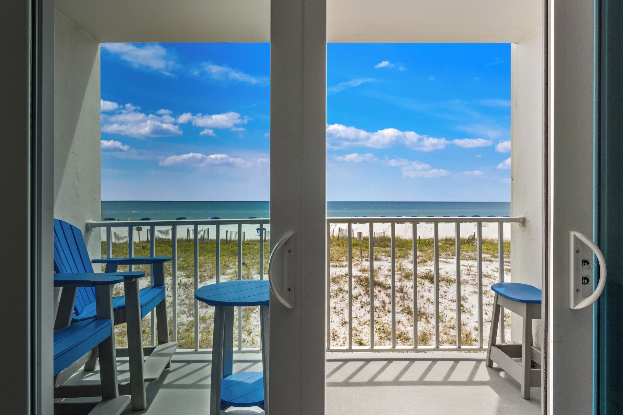A balcony with a view of the beach and ocean.