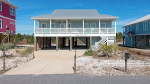 A two-story house with a balcony, a covered porch, and a number 5673 sign. - Living The Dream by Southern Vacation Rentals (Gulf Shores)
