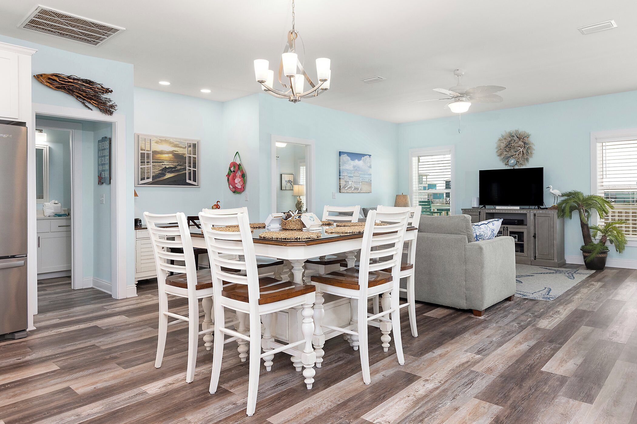 A spacious living room with a dining area, a gray sofa, and a flat-screen TV.
