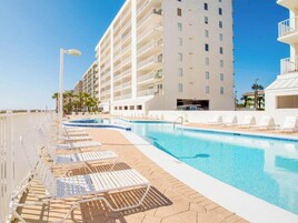 A hotel pool area with lounge chairs and a clear blue pool.