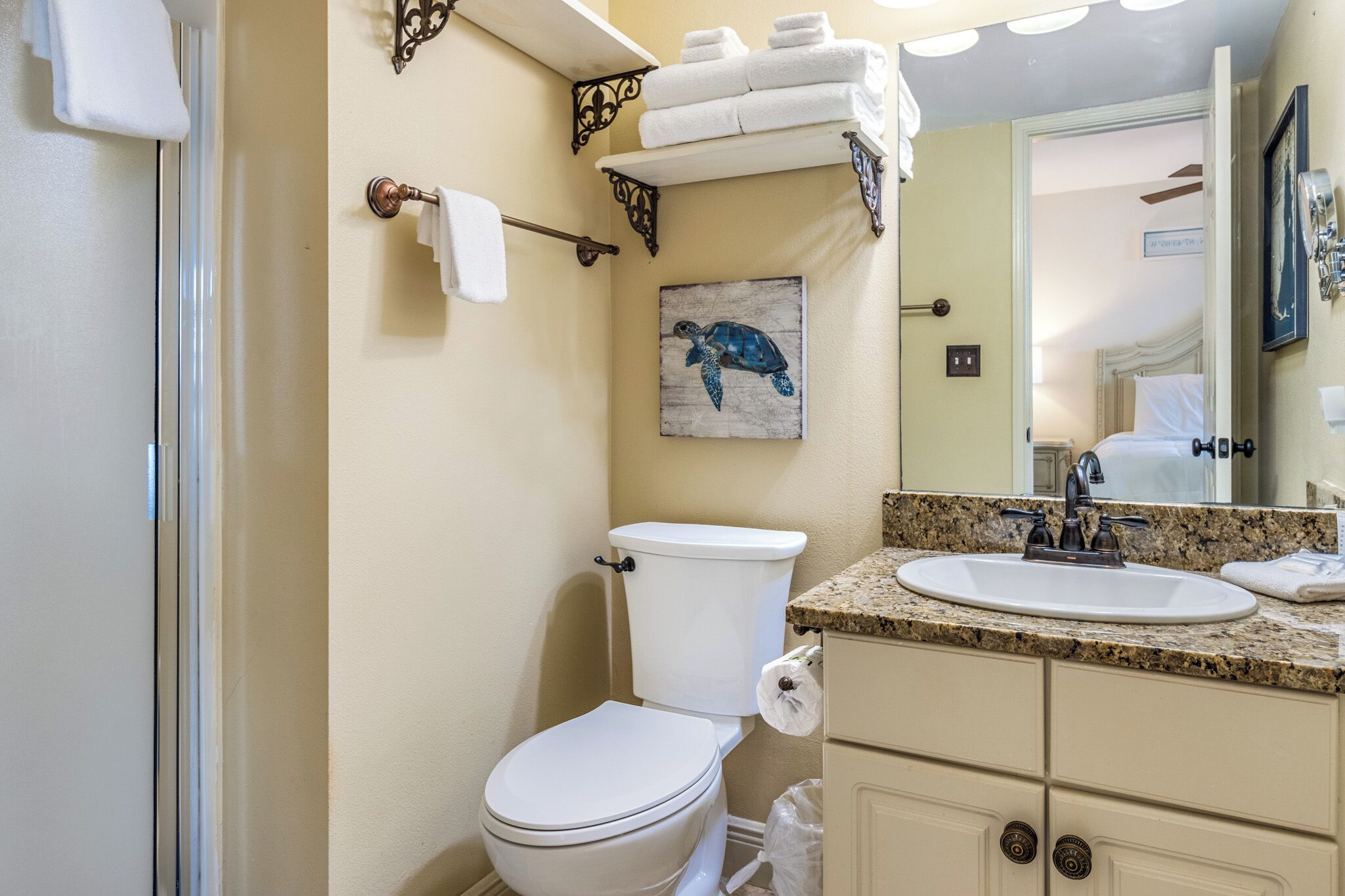 Une salle de bain équipée de toilettes, d’un lavabo et d’un porte-serviettes.