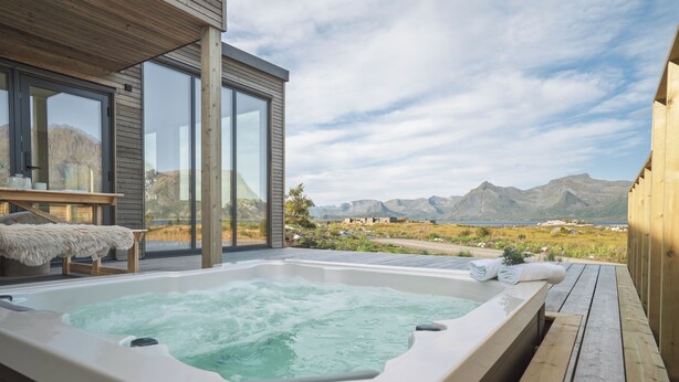 A hot tub on a wooden deck with a mountain view. - Stunning Lofoten Lodge with Views & Jacuzzi (Kleppstad)
