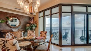 A spacious room with a large glass door leading to a balcony with a view of the sea. - Phoenix West by Southern Vacation Rentals (Orange Beach)