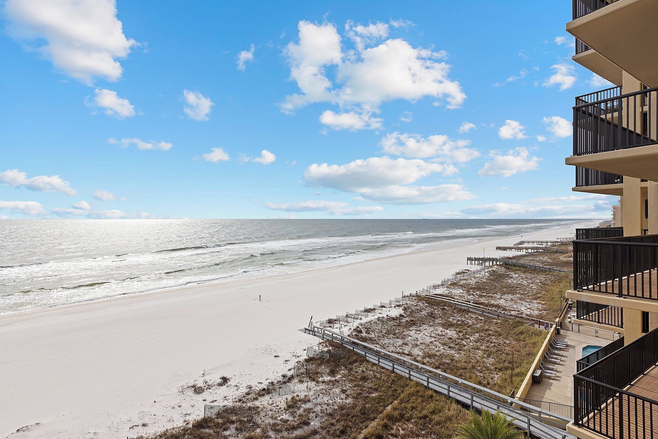 A beachfront hotel with a view of the ocean and beach.