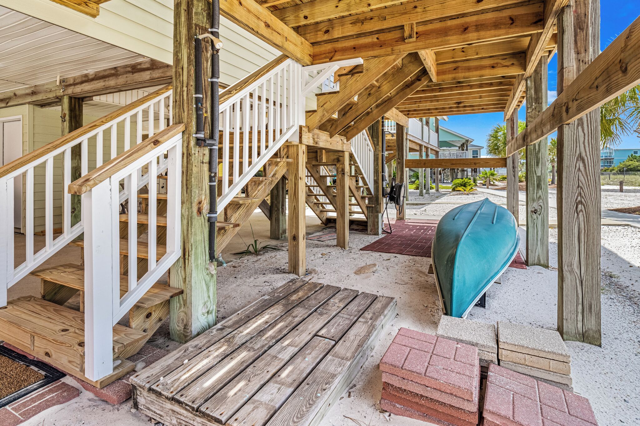 A wooden staircase leading to a covered area with a boat.
