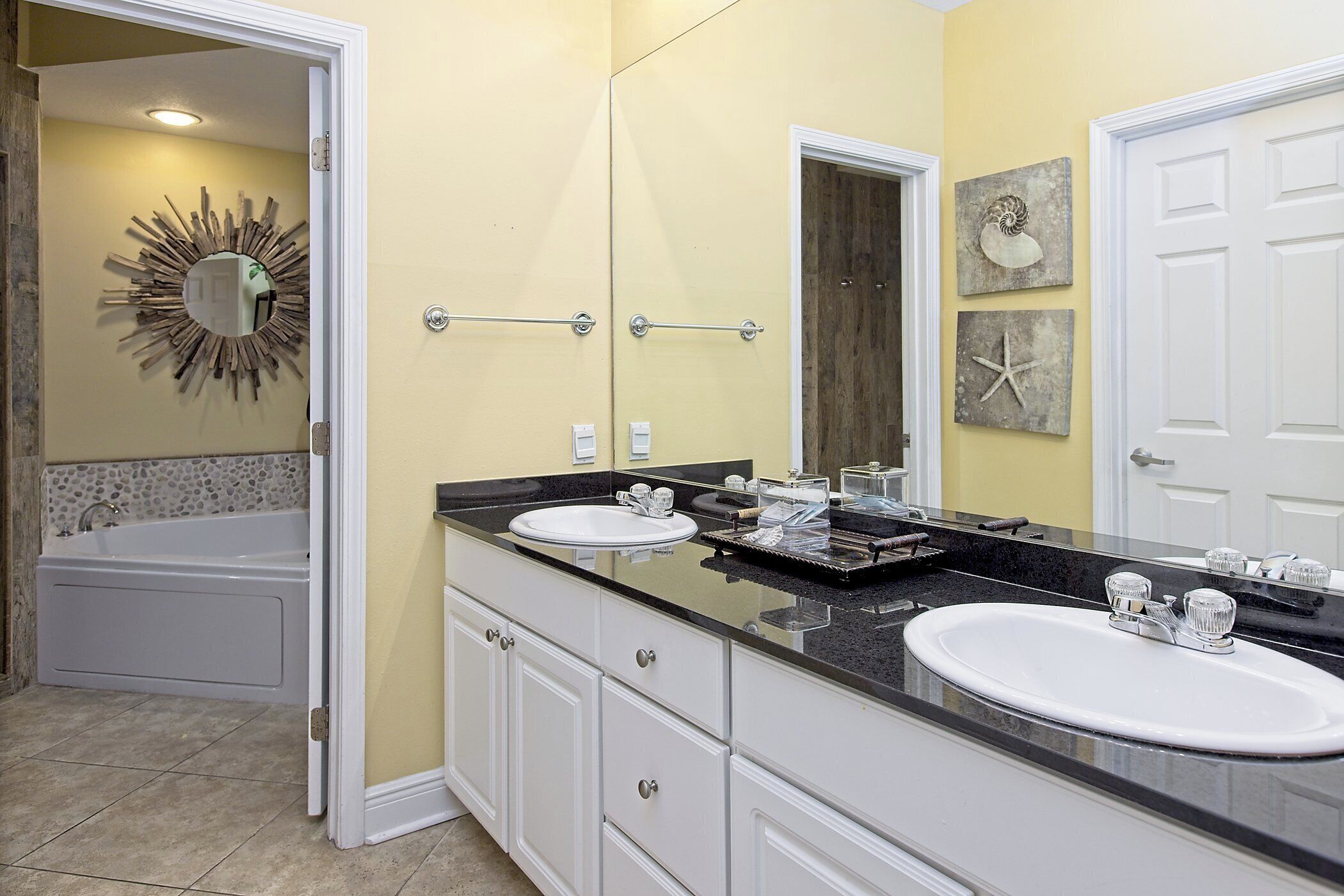 Un baño con dos lavamanos, una bañera y un mueble de tocador con cajones.
