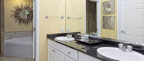 Un baño con dos lavamanos, una bañera y un mueble de tocador con cajones.