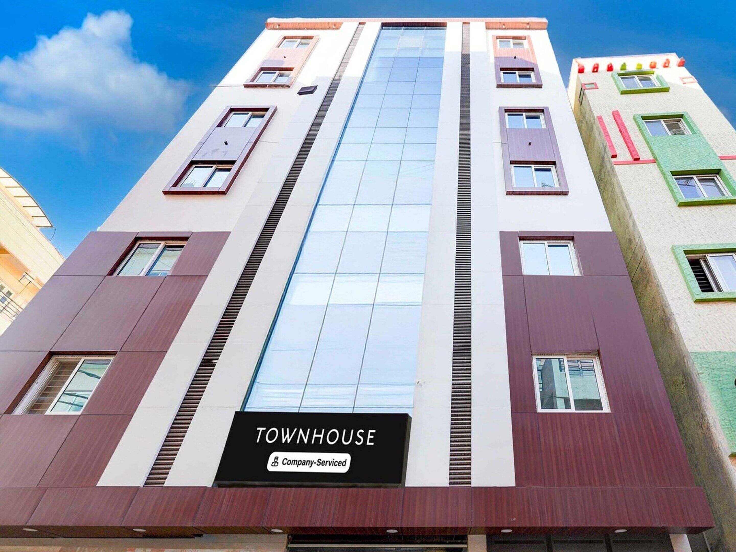 Um edifício de vários andares com uma placa indicando 'TOWNHOUSE Company-Serviced'.