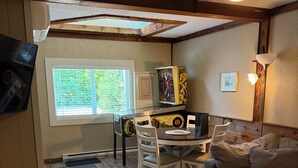 A room with a ceiling fan, a dining table with chairs, a couch, and a TV mounted on the wall. - Welcome to “The Pines” at The Cedars (Cultus Lake)