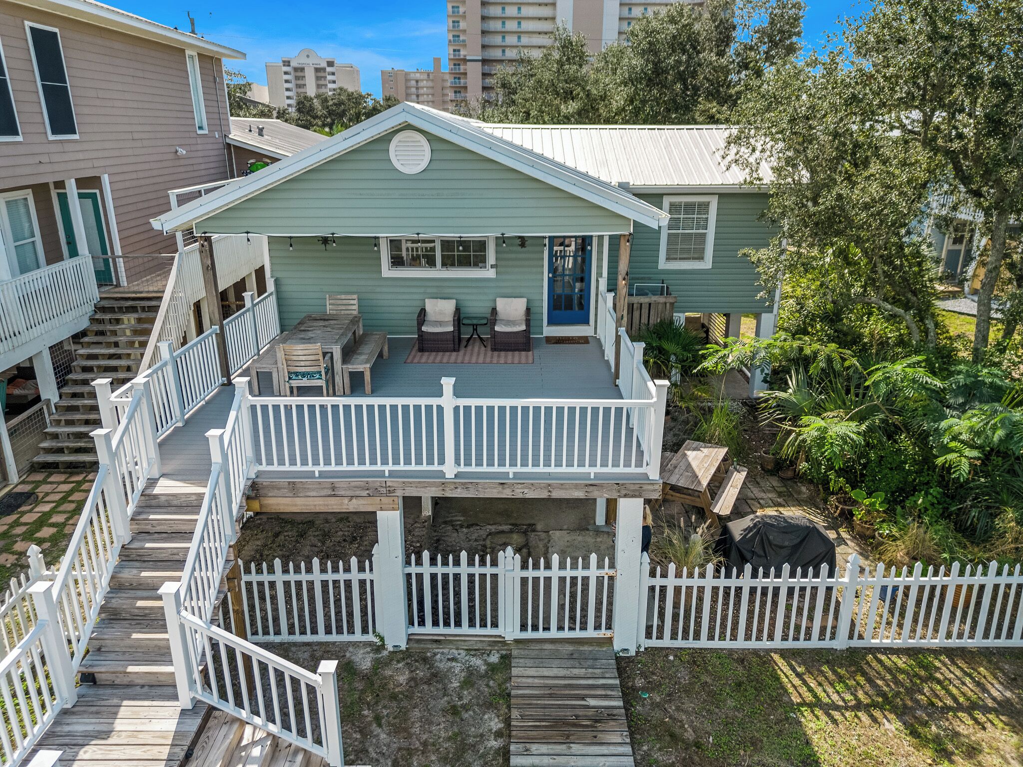 A two-story house with a balcony, a covered patio, and a fenced deck area.