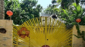 Une porte jaune ornée d’un motif en forme d’éventail, un mur de briques et une enseigne sur laquelle on peut lire : « CASA SAMAY MAZUNTE ».