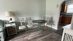 A dining area with a round table and four chairs, a small side table with a lamp, and a sofa. - 2 BR 1 BA Near Marshwalk, pet friendly, NO stairs! (Murrells Inlet)