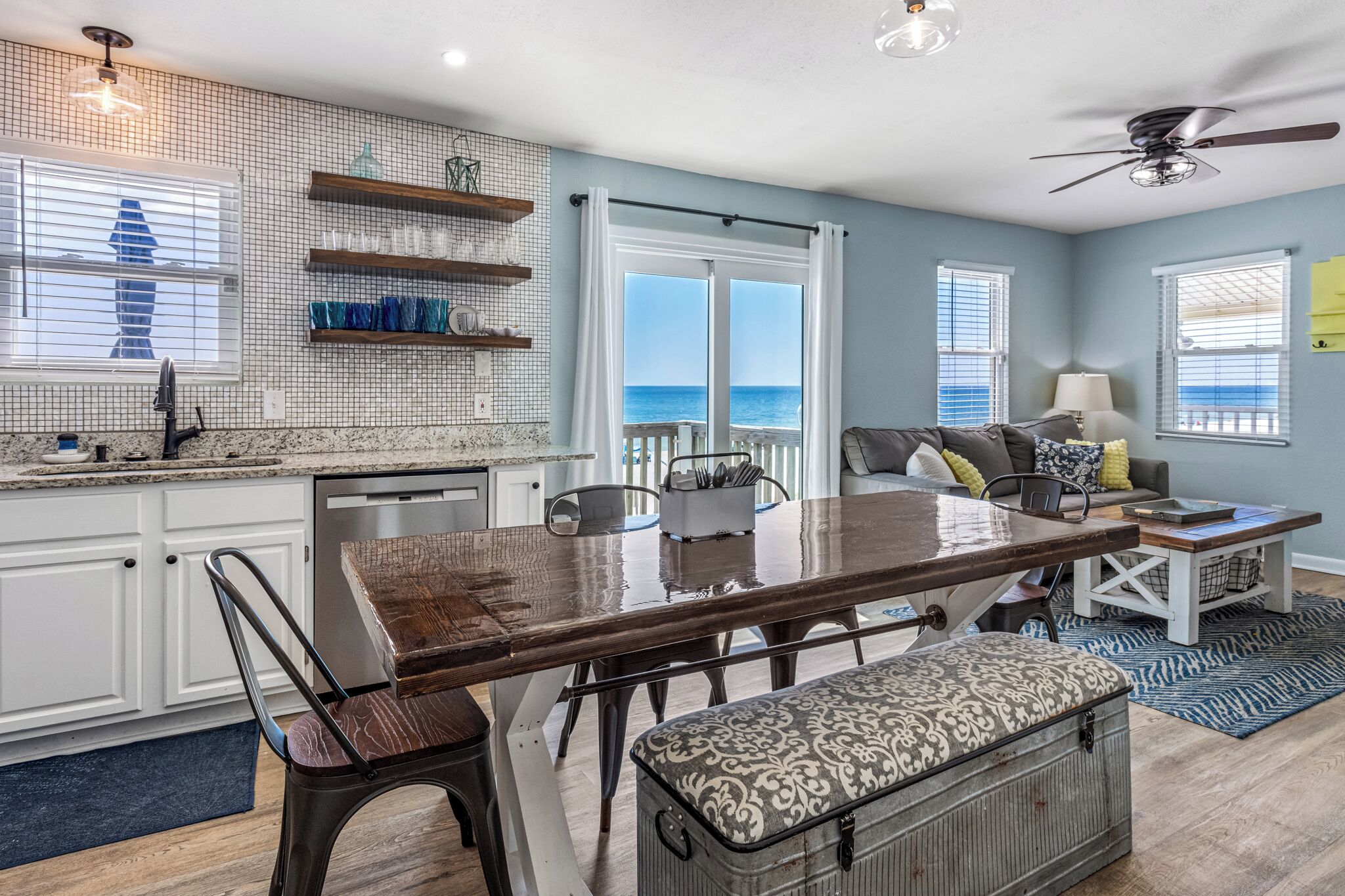 A spacious living area with a dining table, seating, and a view of the ocean.