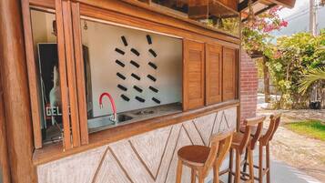 A wooden bar area with a counter, stools, and a decorative wall.