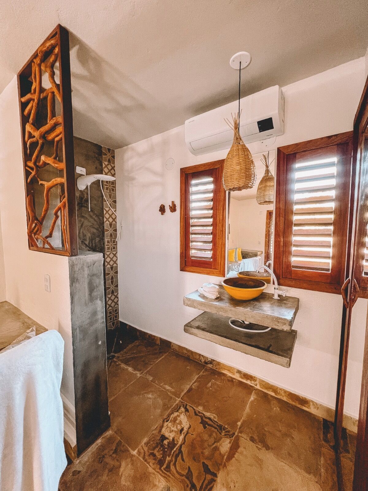A bathroom with a stone sink, wooden accents, and a mirror.
