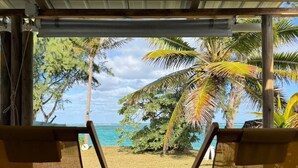 Two yellow lounge chairs facing a beach with palm trees and a clear sky. - Tilakaz Kreol (Pointe d'Esny)